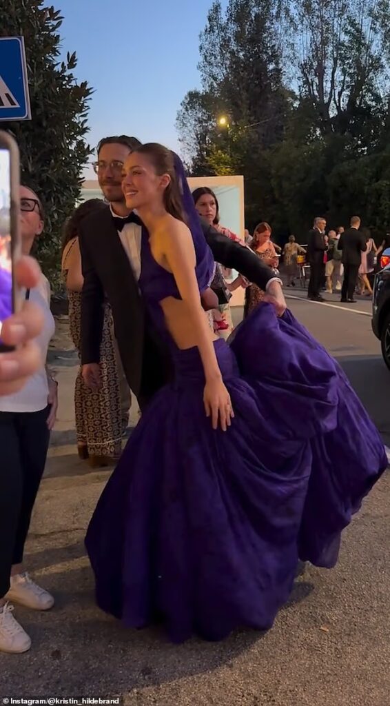 Brooklyn Beckham proves himself to be the perfect assistant as he dutifully carries wife Nicola Peltz’s couture Balenciaga gown at the Venice Film Festival