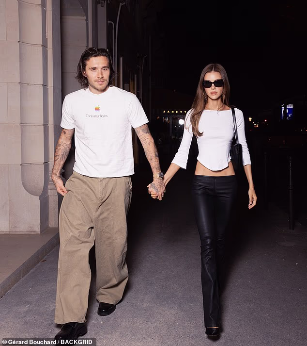 Brooklyn Beckham and Nicola Peltz walk hand in hand as they arrive in the French capital for Paris Fashion Week – just days before estranged mum Victoria’s show