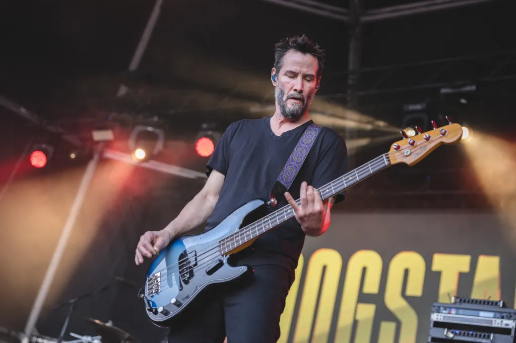 Keanu Reeves Reacts to ‘Love Will Tear Us Apart’ at Peter Hook show
