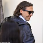 Brooklyn Beckham, 27, reveals salt and pepper flecks in his hair as he and Nicola Peltz arrive at the Balenciaga show – one day before estranged mum Victoria’s Paris Fashion Week event