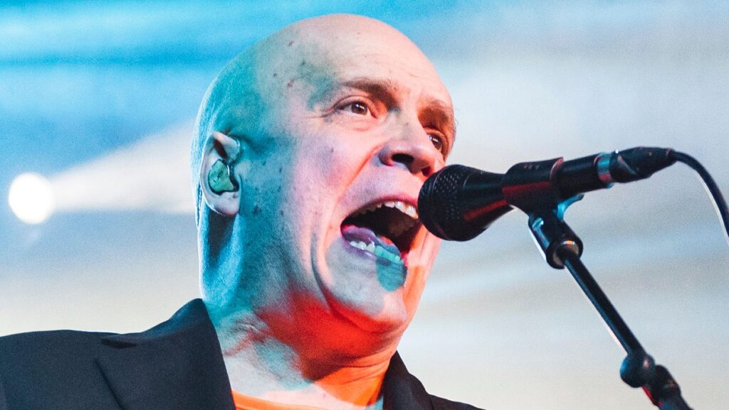 Why is metal guitarist Devin Townsend out on the road again just a year and a half after taking an “indefinite” break from touring?: “Financial armageddon”
